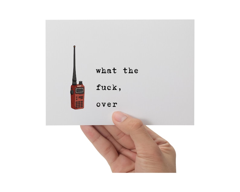 Pu&ograve; includere: Una carta bianca tenuta in mano, con un'illustrazione di walkie-talkie rosso e il testo "what the fuck, over" in nero. Il walkie-talkie ha un'antenna nera e un piccolo schermo.