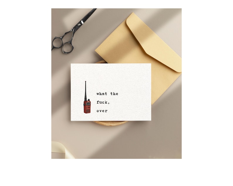 Pu&ograve; includere: Un biglietto di auguri con il testo "what the fuck, over" e un'illustrazione di walkie-talkie rosso. Il biglietto &egrave; su una superficie neutra con una busta beige e forbici.