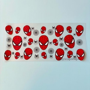 May include: A clear sheet featuring a repeating pattern of red and black Spider-Man mask designs. The masks are in various sizes, with white eye details. Also included are black spider and web designs.