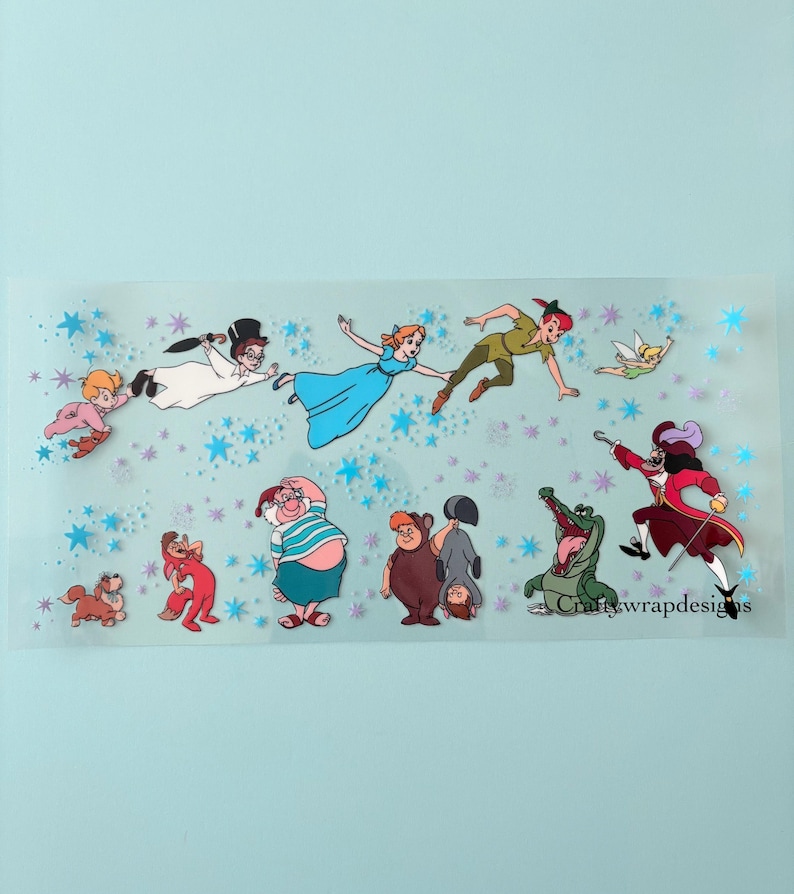 May include: A clear sticker featuring characters from Peter Pan, including Peter Pan, Wendy, Captain Hook, and Tinkerbell. The sticker has a light blue background with blue star accents and the text "craftywrapdesigns".