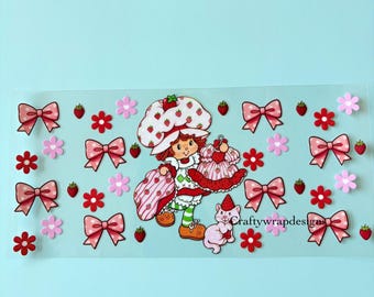 Op de afbeelding: Decoratieve sticker met een stripfiguur met een aardbeienhoed, die een jurk en een tas vasthoudt. Het ontwerp bevat roze strikken, bloemen en aardbeien op een lichtblauwe achtergrond. Een kat is ook inbegrepen.