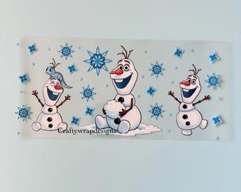 Pode incluir: Um adesivo transparente com três bonecos de neve de desenho animado com rostos sorridentes e braços de pau. Os bonecos de neve são brancos com botões pretos e narizes de cenoura. Flocos de neve azuis e o texto "Craftywrapdesigns" também estão presentes.