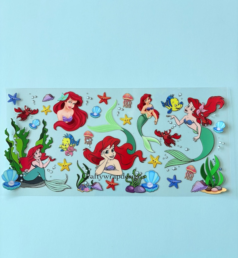 K&ouml;nnte beinhalten: Ein Stickerbogen mit Ariel aus Arielle, die Meerjungfrau. Die Sticker zeigen Ariel mit roten Haaren und einem gr&uuml;nen Schwanz, sowie andere Meereskreaturen wie Seesterne, Krabben und Quallen. Die Sticker befinden sich auf einem transparenten Hintergrund.