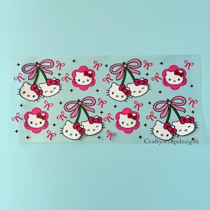 May include: A sheet of stickers featuring a repeating pattern of Hello Kitty faces, pink bows, and cherry-like designs. The stickers have a white background with black outlines and are accented with small black stars. The text "Craftywrapdesigns" is visible.