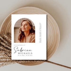 May include: A white memorial card with a photo of a woman in a brown jumper. The text reads "In loving memory of Sabrina MICHAELS 01.01.1948 - 05.04.2025"