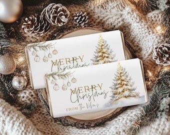 May include: Two rectangular Christmas-themed gift boxes with a white background, gold text, and a watercolor Christmas tree design. The text reads "MERRY Christmas" and "FROM The Wilsons". The boxes are surrounded by pinecones, ornaments, and greenery.