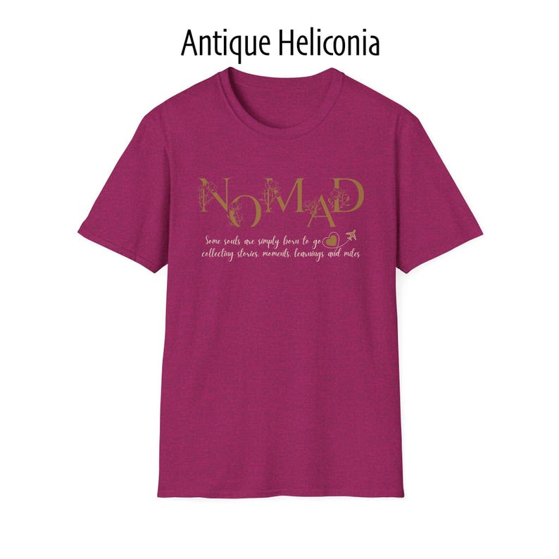 May include: A short-sleeved, magenta t-shirt with the word "NOMAD" in gold script. Below the word is the text "Some souls are simply born to go collecting stories, moments, learnings and miles."