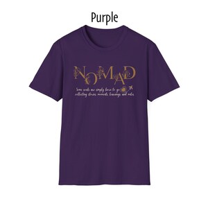 May include: Purple t-shirt with the word "NOMAD" in gold lettering. Below the word "NOMAD" is the text "Some souls are simply born to go collecting stories, moments, learnings and miles."
