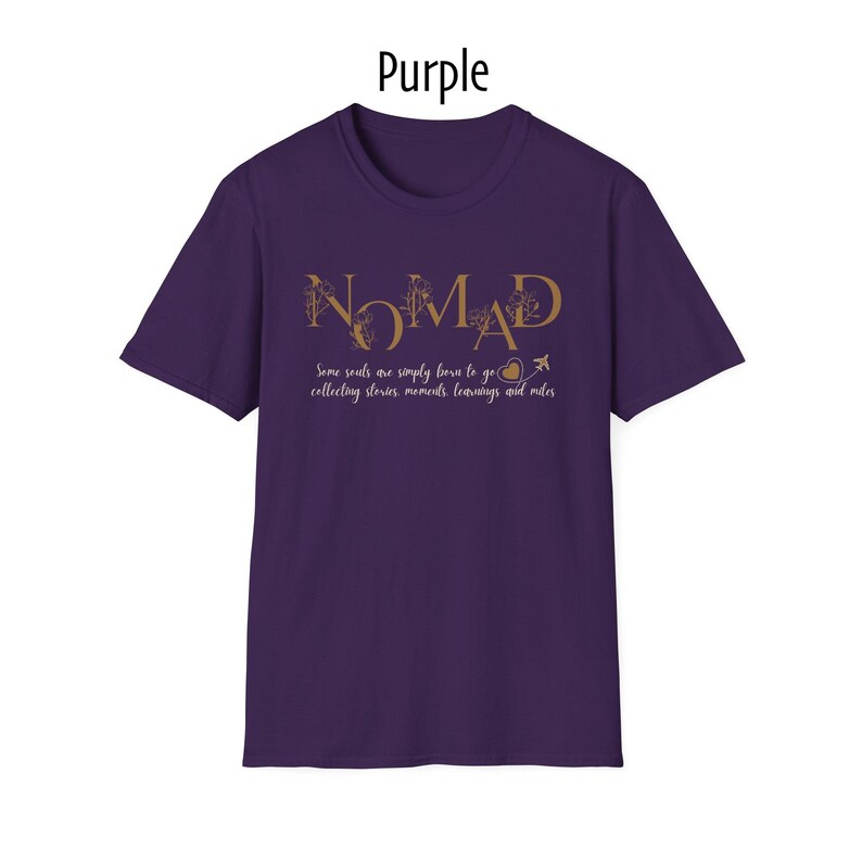 May include: Purple t-shirt with the word "NOMAD" in gold lettering. Below the word "NOMAD" is the text "Some souls are simply born to go collecting stories, moments, learnings and miles."