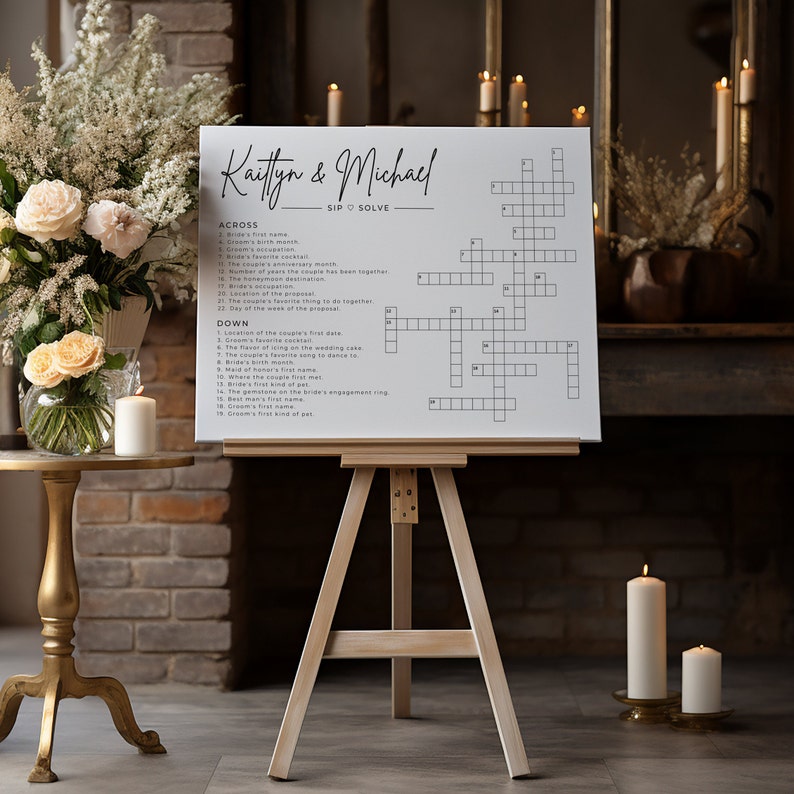 May include: A white crossword puzzle sign with the names Kaitlyn & Michael at the top. The sign is on a wooden easel and has a black and white design. The crossword puzzle is a fun way to entertain guests at a wedding reception.