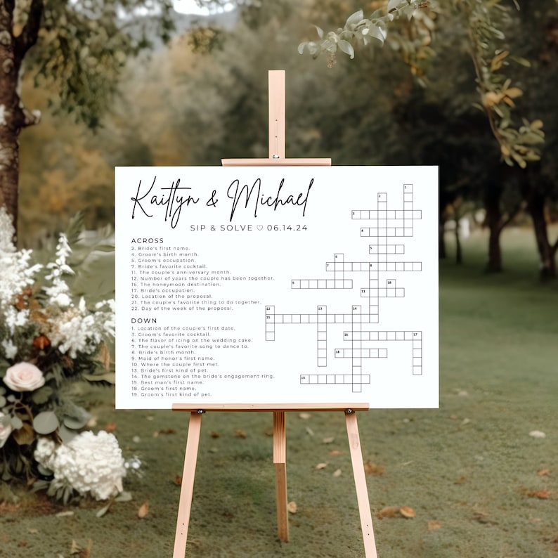 May include: A white wedding sign with a crossword puzzle on it. The sign says "Kaitlyn & Michael Sip & Solve 06.14.24" at the top. The crossword puzzle has clues about the couple's wedding.