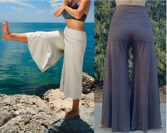 Könnte beinhalten: Zwei Paar weite Hosen, eine in hellem Beige und die andere in dunkel Anthrazitgrau. Beide Hosen haben eine hohe Taille und ein fließendes, weites Bein.