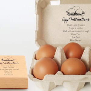 May include: A carton of brown eggs with the text "Egg Instructions". The instructions include room temperature and fridge storage times, and a water test. A wooden stamp with the same text is also visible.