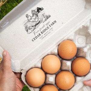 May include: A carton of brown eggs with the text "Farm fresh eggs" and "Cedar Ridge Farm" printed on the inside lid. The carton contains six eggs. The carton is held by a person.
