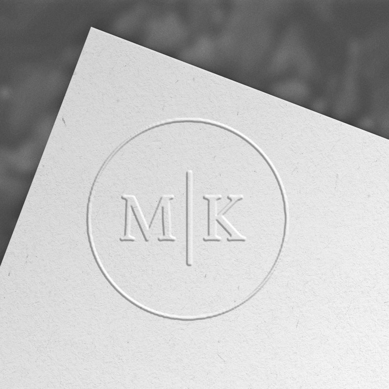 May include: A white circle with a black line dividing it in half. The letters "M" and "K" are on either side of the line.