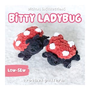 May include: Two small crocheted ladybugs with red wings featuring white spots and black bodies. The text reads Digital Instructions Bitty Ladybug Low-Sew crochet pattern. The ladybugs have a textured yarn appearance with small black eyes.