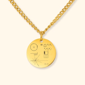 Könnte beinhalten: Eine goldfarbene Halskette mit einem kreisförmigen Anhänger. Der Anhänger, der an einer goldenen Kette hängt, zeigt eingravierte schwarze Grafiken. Das Design umfasst geometrische Formen und Linien und schafft eine einzigartige und künstlerische Ästhetik.