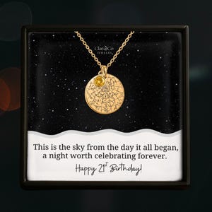 May include: Gold necklace with a circular pendant showing a star map and a yellow gemstone. The necklace is presented in a black box with the text "This is the sky from the day it all began, a night worth celebrating forever. Happy 21st Birthday!"