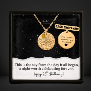 May include: Gold-colored necklace with two pendants. One pendant features a star map design with a yellow gemstone, the other is a blank circle with a heart. Text reads "Back Engraving" and "Your custom message on the back". The text "Happy 45th Birthday!" is also visible.