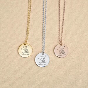 May include: Three gold, silver, and rose gold necklaces with a round pendant featuring a cartoon bear holding a honey pot. The pendant says "Mama Bear" on the bottom.