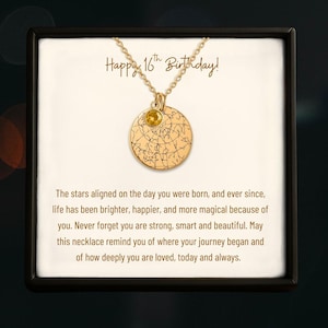 May include: Gold-colored necklace with a round pendant featuring a star map design and a small yellow gemstone. The text "Happy 16th Birthday!" is above the necklace. The necklace is presented in a black box.