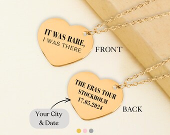 May include: Gold heart-shaped necklace with a chain. The front of the pendant says "IT WAS RARE, I WAS THERE". The back of the pendant says "THE ERAS TOUR STOCKHOLM 17.05.2024".