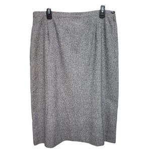 May include: A gray pencil skirt with a subtle pattern. The skirt is knee-length and has a straight silhouette.