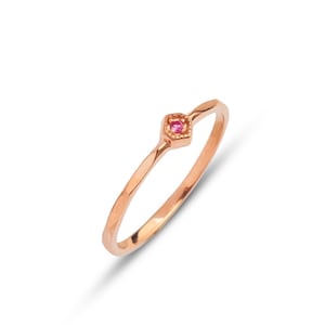 以下が含まれることがあります： 小さなピンクの宝石が正方形にセットされた、繊細なローズゴールドのリングです。