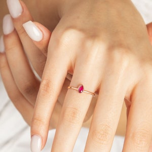 以下が含まれることがあります： 小さな涙型のルビーの宝石が付いた繊細な金の指輪
