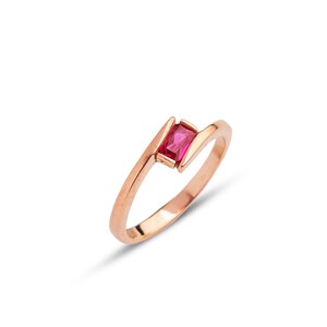 May include: A rose gold ring with a single red gemstone set in a twisted band.