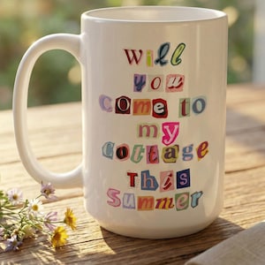 Może przedstawiać: Biały ceramiczny kubek z napisem "Will you come to my cottage this summer" w kolorowych, wyciętych literach. Kubek ma duży uchwyt i stoi na drewnianej powierzchni.