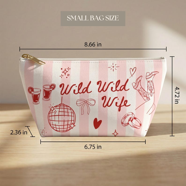 May include: A small, pink and white striped bag with the text "Wild Wild Wife" and illustrations of cocktails, a disco ball, boots, and rings. The bag measures 8.66 inches wide, 4.72 inches high, and 2.36 inches deep.