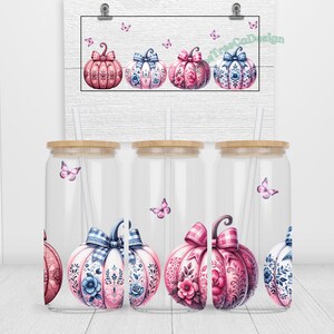May include: Three clear glass tumblers with bamboo lids and pink and blue patterned pumpkins with butterflies. The tumblers are decorated with a fall theme.