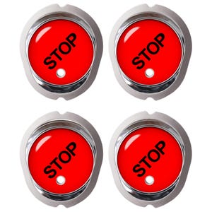 Può includere: Quattro bottoni circolari con bordo in metallo color argento lucido e centro rosso brillante. Ogni bottone presenta la parola STOP stampata in grassetto con lettere maiuscole nere e un piccolo foro circolare sotto il testo per il fissaggio.