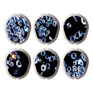 Può includere: Sei sottobicchieri rotondi con bordo argentato, sfondo nero e diamanti blu e bianchi scintillanti sparsi.