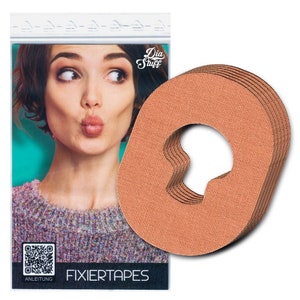 Può includere: Un pacchetto di otto nastri adesivi in tessuto beige con un foro al centro. I nastri sono progettati per tenere gli oggetti in posizione. La confezione presenta il testo "Dia Stuff" e "Fixiertapes".