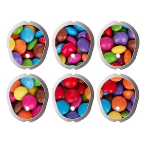 Pode incluir: Um conjunto de seis coberturas ovais de plástico branco, cada uma com um orifício circular central e um padrão colorido de doces redondos cobertos de chocolate em tons de vermelho, azul, verde, amarelo, laranja, roxo e castanho.
