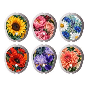 Può includere: Un set di sei coperture decorative ovali con stampe floreali. Ogni pezzo mostra un diverso design botanico: un girasole giallo, peonie rosa, fiordalisi e margherite blu, papaveri rossi, iris viola e dalie arancioni.