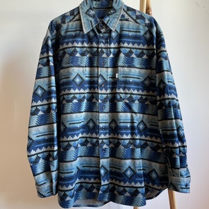 Könnte beinhalten: Ein langärmliges Hemd mit Knöpfen und einem geometrischen Muster in Blau- und Grautönen.