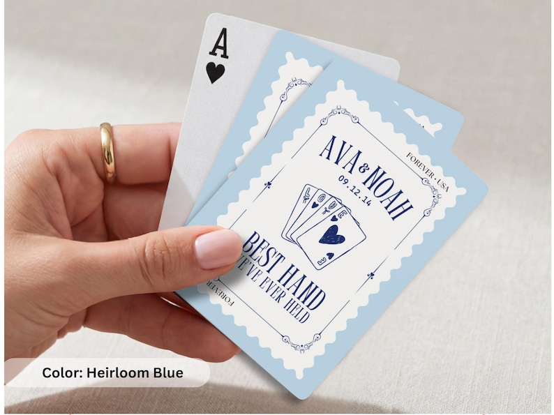 K&ouml;nnte beinhalten: Ein Kartenspiel mit einem hellblauen, briefmarkenf&ouml;rmigen Rand und dunkelblauem Text, der AVA & NOAH, 09.12.14 und BEST HAND WE'VE EVER HELD lautet, sowie einer Grafik von vier Spielkarten, die ein Herz-Symbol zeigen.