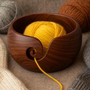 May include: A wooden yarn bowl with a spiral design holds a bright yellow ball of yarn. Two other yarn balls, one gray and one brown, are in the background. A cream-colored knitted item and a gray knitted item are also in the image.