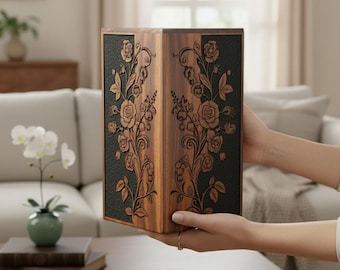 May include: A wooden box with intricate floral carvings. The box is held by hands and features a dark green panel with carved roses and leaves. The wood has a warm, brown tone, and the design is symmetrical.