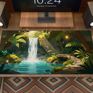 May include: A rectangular desk mat featuring a vibrant illustration of a lush forest scene with a central waterfall cascading into a turquoise pool, surrounded by green ferns, mossy rocks, glowing blue orbs, and a stone arched bridge.