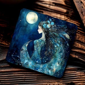 May include: Square coaster with a celestial illustration of a woman with flowing hair, decorated with flowers, beneath a full moon. The artwork uses blue and teal tones, creating a dreamy theme.
