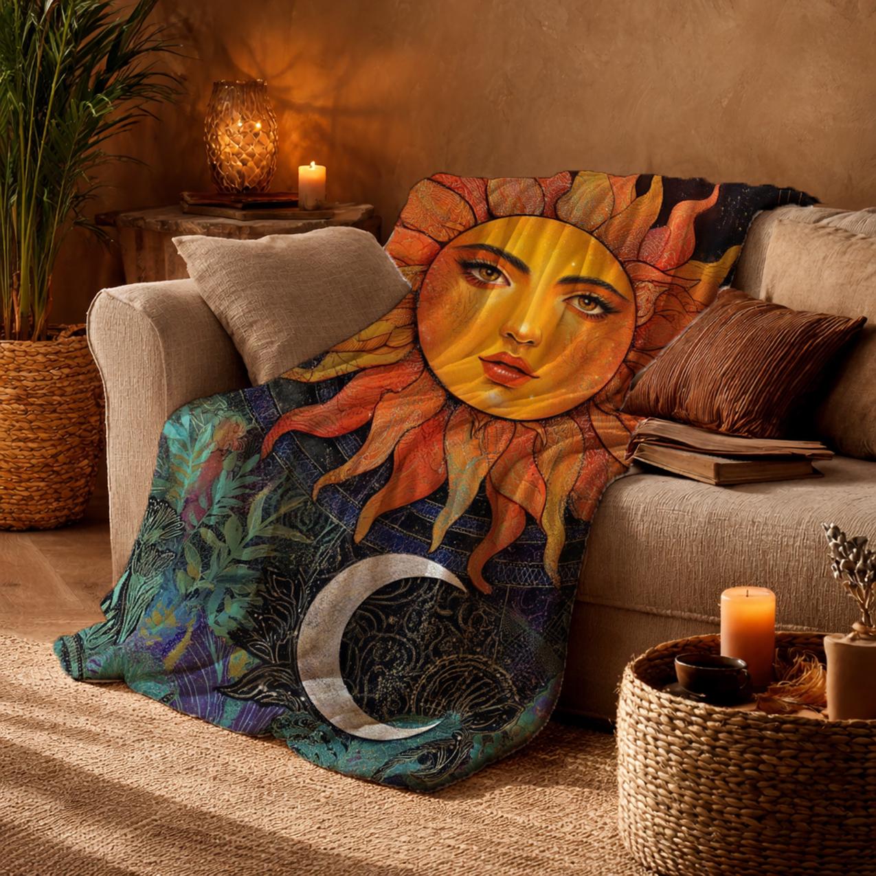 Könnte beinhalten: Eine weiche Wohndecke mit einem großen, zentralen Sonnengesicht mit goldenen Strahlen vor einem dunklen Hintergrund, ergänzt durch eine Mondsichel und komplexe botanische Muster in Orange, Gelb, Blau und Grün, drapiert über ein Sofa.