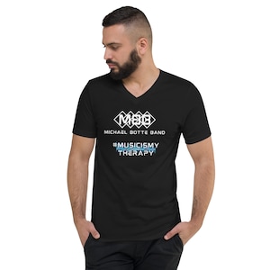Könnte beinhalten: Schwarzes V-Ausschnitt-T-Shirt mit einem weißen Logo, das "M&B Michael Botte Band" sagt, und dem Text "#MUSICISMYTHERAPY" in Weiß mit einer blauen Grafik darunter.