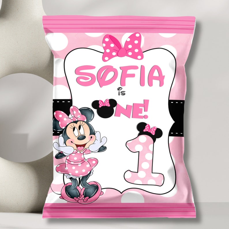 May include: Pink and white polka dot treat bag with a Minnie Mouse character and the text "Sofia is One!"