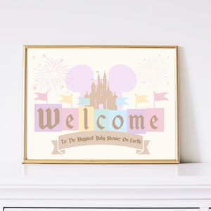 May include: A printable welcome sign for a baby shower with a pastel pink, blue, and yellow color scheme. The sign features a silhouette of Cinderella's castle with fireworks and the word "Welcome" in a whimsical font. The text at the bottom reads "To the Happiest Baby Shower On Earth!"