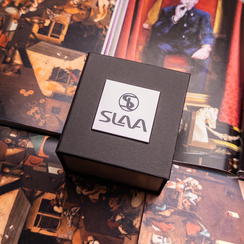 May include: A black square box with a white logo that says "SLAVA" with a stylized "S" inside a circle.