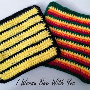 Könnte beinhalten: Zwei gehäkelte Topflappen, einer mit schwarzen und gelben Streifen und der andere mit roten, orangen, gelben und grünen Streifen. Der Text "I Wanna Bee With You" steht unter den Topflappen.
